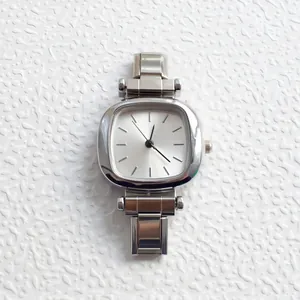Close-up of a silver cushion-shaped women's watch with a minimalist dial and link band