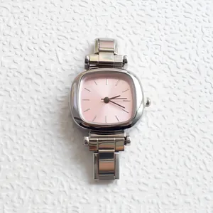 Detail of a square women's watch featuring a soft pink dial and silver link bracelet