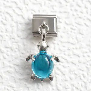 Detailed macro of a sea turtle charm with a blue crystal gem for modular bracelets