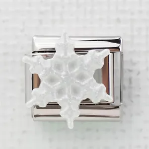 Macro-opname van een Italiaanse armbandbedel met een glinsterende witte sneeuwvlok decoratie