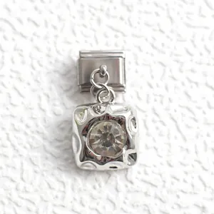 Detailed macro of a silver Italian charm link featuring a clear round cut crystal stone