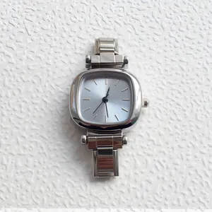 Macro shot of silver stainless steel watch showing light blue sunray dial and link bracelet
