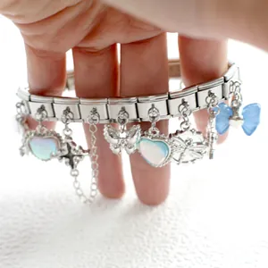 Close-up of Italian charm bracelet with iridescent heart, butterfly and dragonfly charms