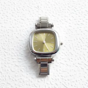 Detail of silver stainless steel pillow-shaped case and champagne dial with minimalist markers