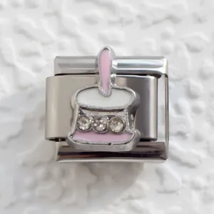 Macro shot of Italian charm bracelet link with pink enamel hat and inlaid crystals