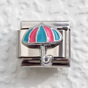 Macro shot of stainless steel modular link with pink and blue enamel umbrella design