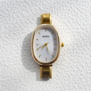 Vue détaillée d'une montre à quartz dorée NAIDU avec cadran ovale sur fond texturé