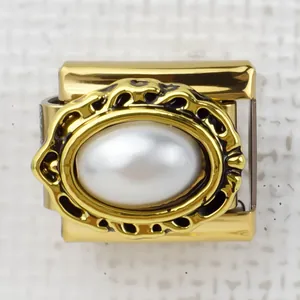 Macro shot of gold Italian charm link with oval white pearl and baroque filigree detail