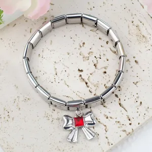 Gros plan d'un bracelet à breloques italien en acier avec pendentif nœud serti de rouge
