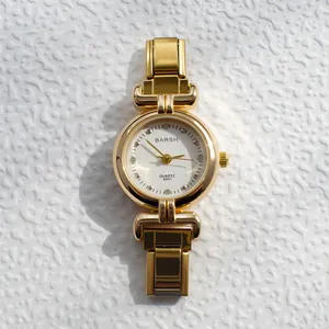 Gros plan détaillé d'une montre à quartz dorée avec index diamants et cadran blanc