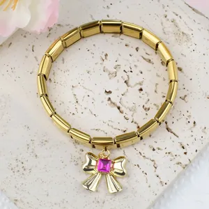 Gros plan d'un bracelet italien doré avec pendentif nœud et pierre rose sur pierre