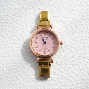 Détails d'une montre à quartz rose dorée pour femme avec cadran rose et index en cristal
