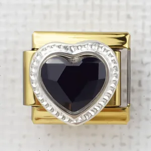 Macro view of Italian charm link featuring heart-shaped black stone and gold base