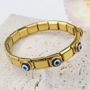 Gros plan d'un bracelet à breloques italien doré avec maillons en émail œil bleu