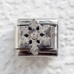 Macro view of Italian modular charm link with snowflake design and inset zircon stone