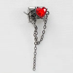 Dettaglio charm italiano con gemma cuore rosso e design ragnatela gotica argentata