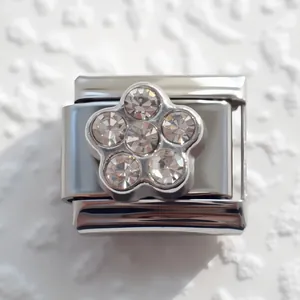 Detailansicht eines Edelstahl-Charm-Links mit funkelndem Blumen-Element aus fünf Kristallen