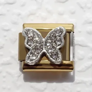 Macro detail of a gold Italian charm link featuring a silver pave butterfly with crystals