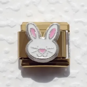 Macro view of a gold-plated Italian charm featuring a white and pink enamel bunny face