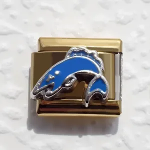 Detail of Italian charm link in gold stainless steel with blue dolphin enamel and glitter