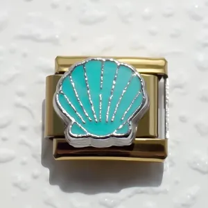 Detalle macro del dije modular italiano con concha de esmalte verde sobre base dorada
