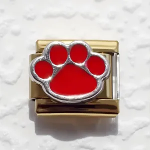 Close-up of golden Italian charm link with red enamel paw print for modular bracelets
