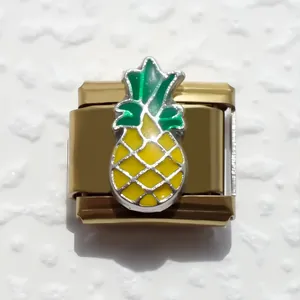 Detalle macro de un charm italiano de acero inoxidable bañado en oro con una piña