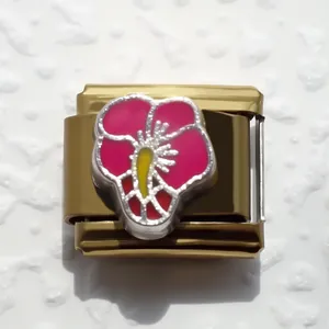 Primer plano de eslabón italiano de acero dorado con diseño de flor rosada