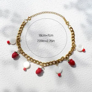 Detail van aardbei hangers aan een gouden ketting met maataanduidingen 18 cm plus 7 cm