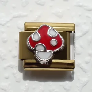 Detalle macro de eslabón de pulsera italiana con diseño de hongo rojo y blanco