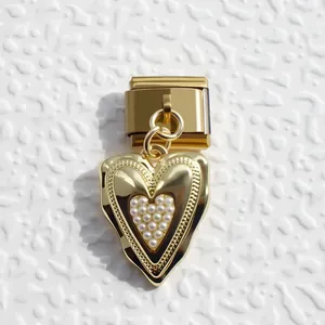 Macro detail of golden heart Italian charm link with white inlaid pearls for DIY bracelets