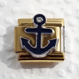 Detailed macro view of a gold-plated stainless steel Italian charm with a blue anchor and crystal