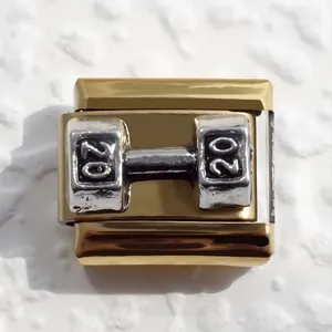 Macro shot of a gold-plated Italian charm featuring a silver dumbbell with number 20