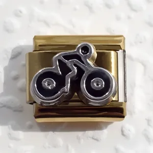 Detail of gold-plated stainless steel Italian charm link with silver bicycle motif