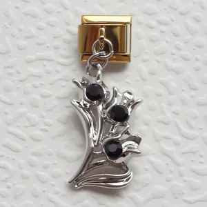 Dettaglio charm modulare italiano con base dorata e pendente floreale in argento e nero
