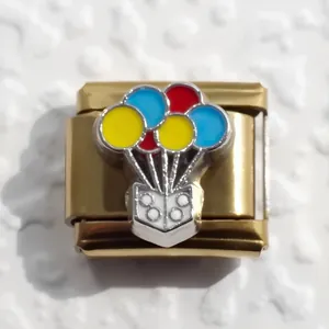 Macro view of gold-plated stainless steel charm with colorful balloon enamel detail