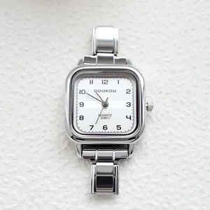 Macro detail of silver square quartz watch with textured white dial and metal link bracelet