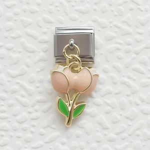 Dettaglio del ciondolo a tulipano rosa smaltato su un bracciale modulare in acciaio