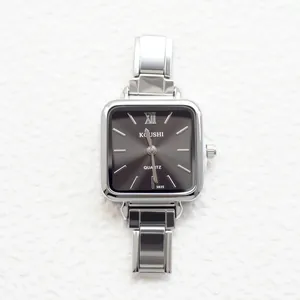 Macro shot of a silver square women's watch with Roman numerals and steel link strap