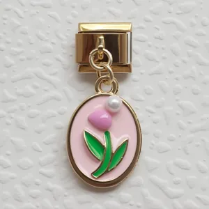 Dettaglio charm italiano dorato con smalto rosa, foglie verdi e piccola perla preziosa