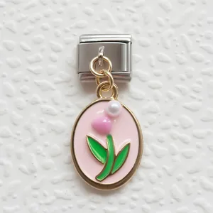 Dettaglio di un link charm italiano con smalto rosa, pendente a cuore e perla in acciaio