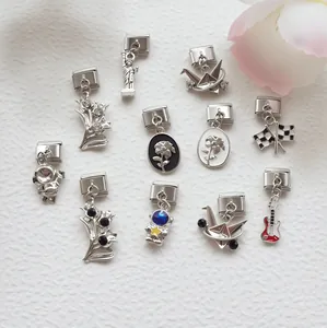 Detailed flat lay of modular Italian charms featuring astronaut, crane, and statue