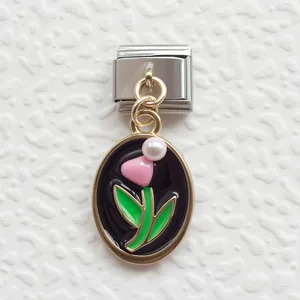 Dettaglio macro dello charm italiano con fiore rosa, perla e base in acciaio dorato