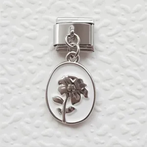 Detail of silver modular charm link with a white floral relief oval pendant
