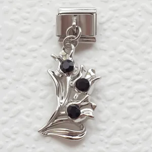 Detail of Italian charm bracelet link with tulip flower design and black gemstones