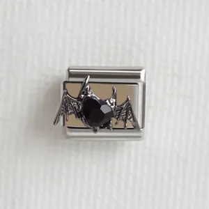 Détail macro d'ailes de chauve-souris gothiques et cœur noir sur breloque italienne