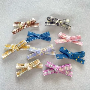 Close-up of 8 DIY plaid fabric bows for doll clothes and crafts in various colors