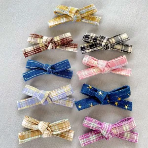 Flat lay detail showing nine assorted checkered and denim DIY bow accessories