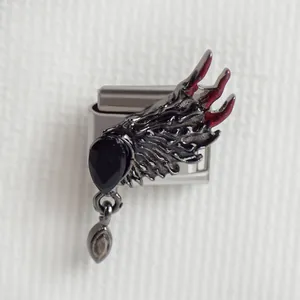 Détail macro du charm italien avec ailes de chauve-souris noires et gemme poire rouge