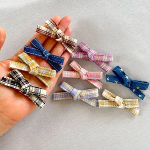 Detail of plaid and denim fabric bows for DIY doll clothing and hair accessories